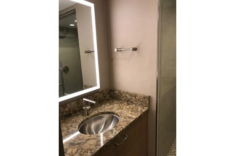 Slide: The Image of Modern bathroom with illuminated mirror, granite countertop, and stainless steel sink. Adonia 7518, 2017. - 11