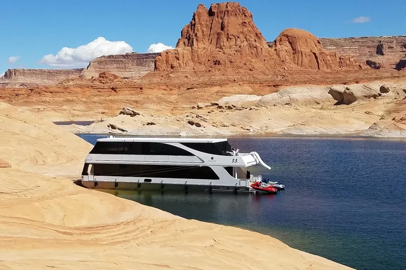 Slide: The Image of Houseboat Adonia 7518 (2017) on serene lake, surrounded by stunning red rock formations. - 12