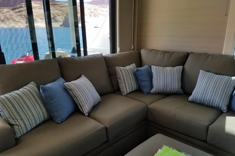 Slide: The Image of Luxurious Adonia 7518 interior with cozy sectional sofa and striped cushions, overlooking serene waters. - 13