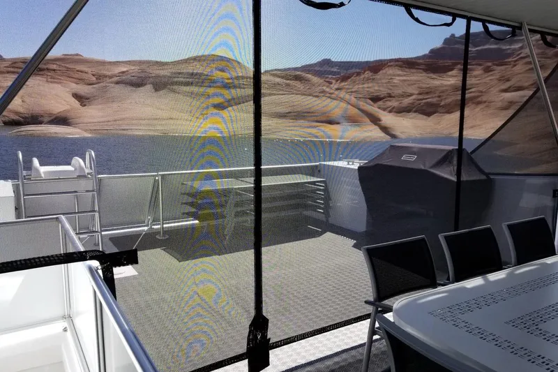 Slide: The Image of Houseboat Adonia 7518 deck with dining area, grill, and scenic lake view, 2017 model. - 17