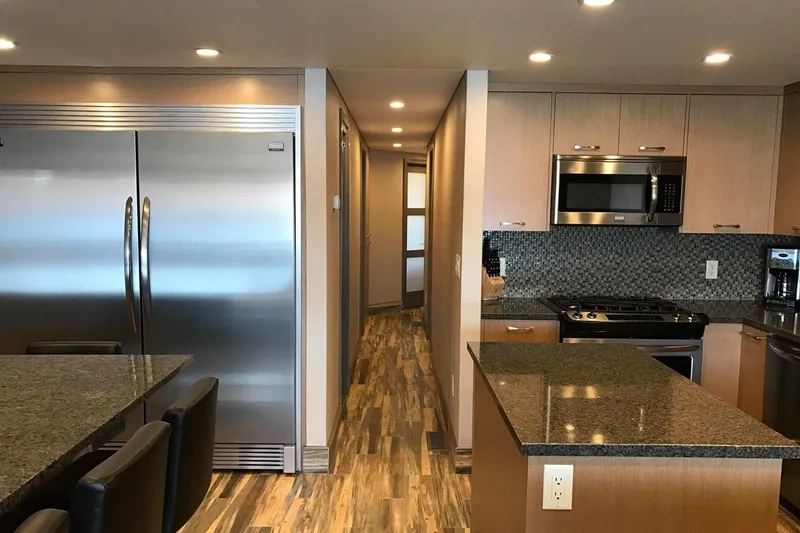 Slide: The Image of Modern kitchen with stainless steel appliances, granite countertops, and wood flooring, Adonia 7518 model. - 4
