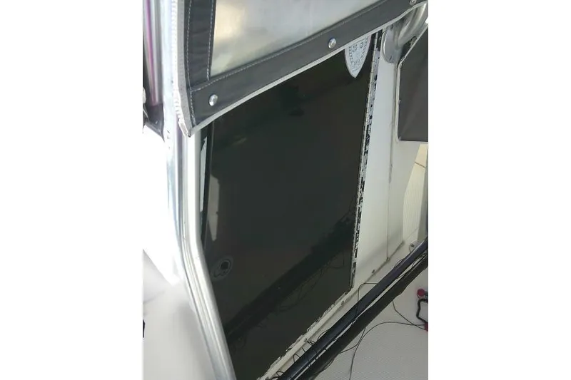 Slide: The Image of 2002 KenCraft Challenger 235 CC boat interior with black panel and protective cover. - 26