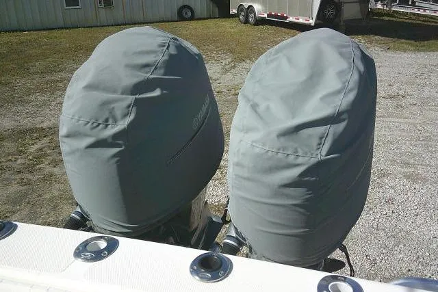 Slide: The Image of Covered outboard motors on a 2002 KenCraft Challenger 235 CC boat, parked on gravel. - 36