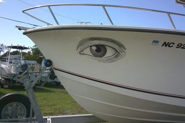 Slide: The Image of 2002 KenCraft Challenger 235 CC boat with eye graphic on hull, parked on trailer. - 4