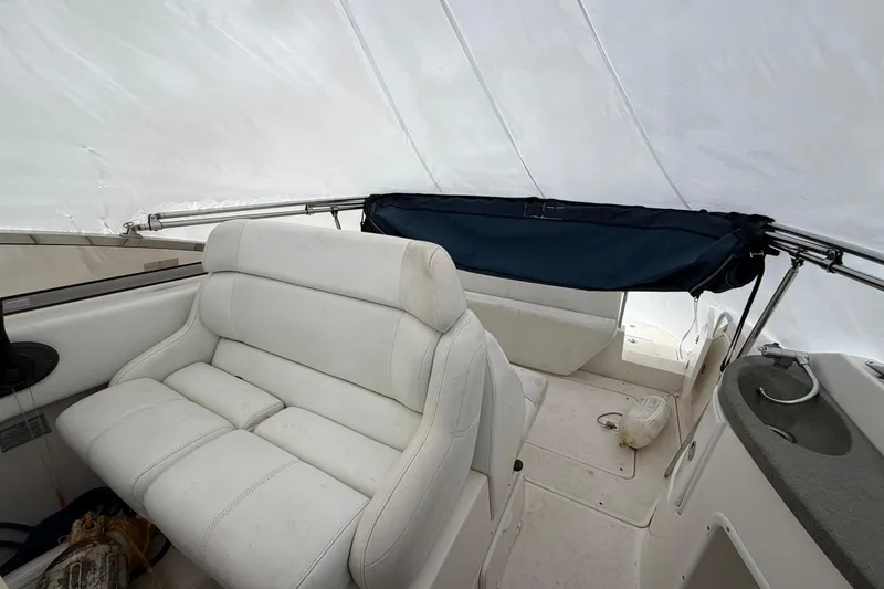 Slide: The Image of 2005 Regal Commodore 265 boat interior with white seating and covered deck. - 10