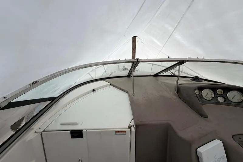 Slide: The Image of 2005 Regal Commodore 265 boat interior under protective cover, showing dashboard and controls. - 13