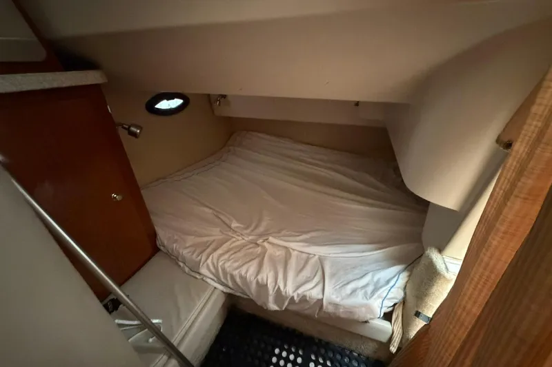 Slide: The Image of Cozy cabin interior of 2005 Regal Commodore 265 with bed and wooden cabinetry. - 15