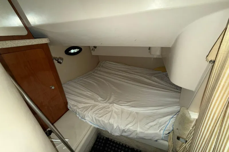 Slide: The Image of 2005 Regal Commodore 265 cabin interior with bed and wooden cabinet. - 16