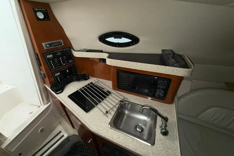 Slide: The Image of 2005 Regal Commodore 265 boat interior with kitchenette, sink, and microwave. - 20