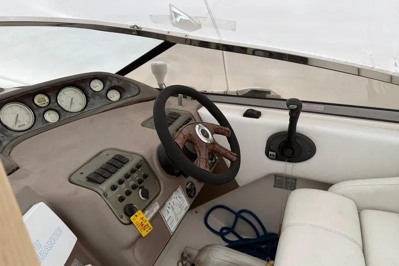 Slide: The Image of 2005 Regal Commodore 265 boat dashboard with steering wheel and control panel. - 22