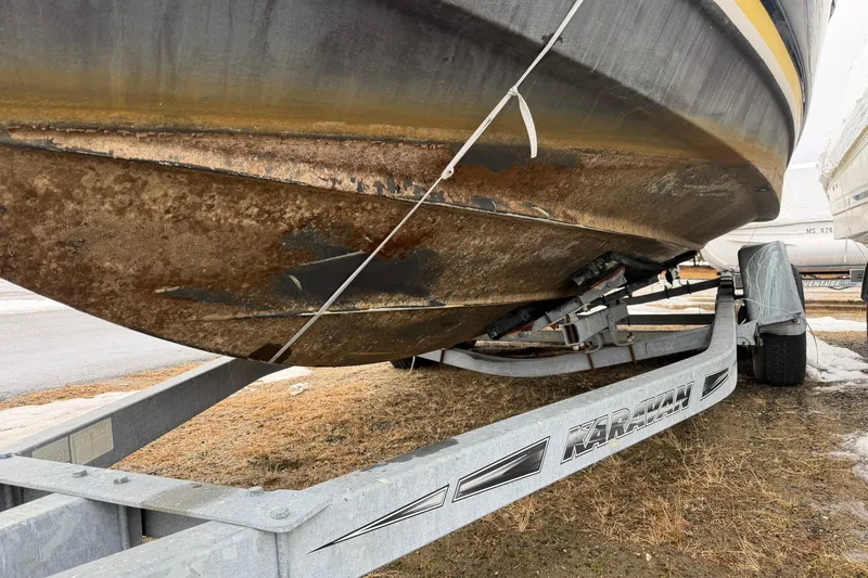 Slide: The Image of 2005 Regal Commodore 265 boat on trailer, showing hull with visible wear and rust. - 35