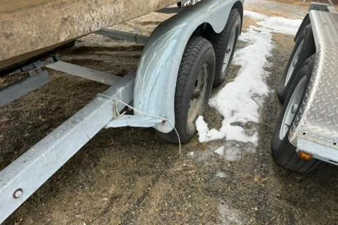 Slide: The Image of Trailer with dual wheels on gravel, near snow patches, for 2005 Regal Commodore 265 boat. - 36