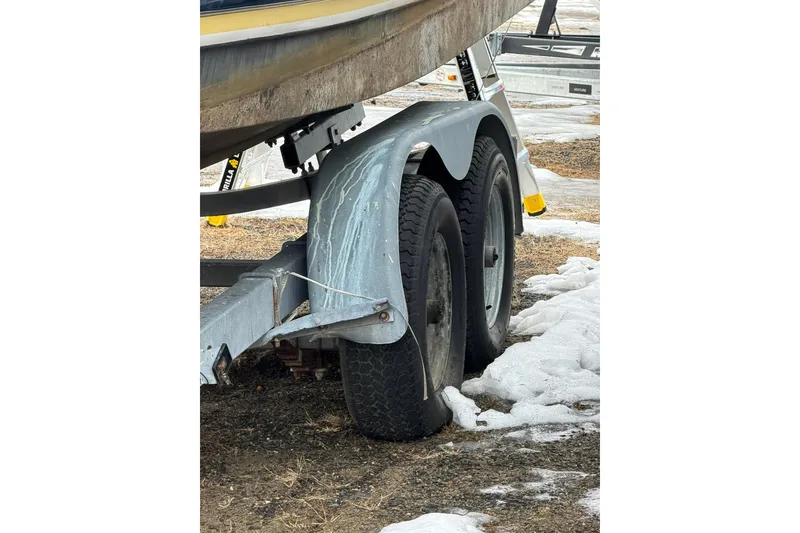 Slide: The Image of Trailer with dual wheels carrying a 2005 Regal Commodore 265 boat on snowy ground. - 37