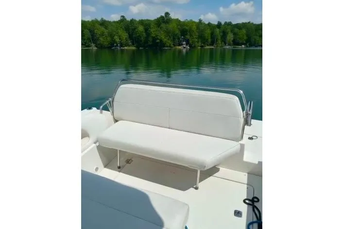 Slide: The Image of 2005 Regal Commodore 265 boat with white seating on a serene lake. - 4