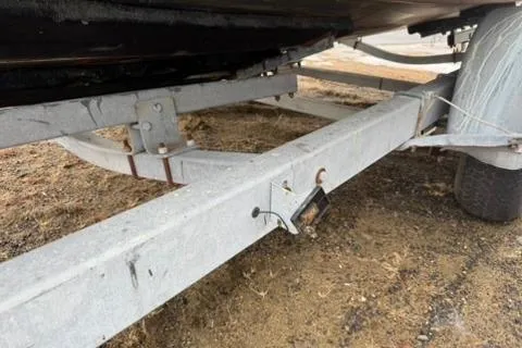 Slide: The Image of Trailer frame for 2005 Regal Commodore 265 boat on sandy ground. - 44