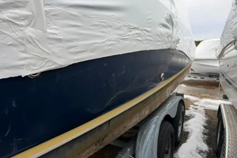 Slide: The Image of 2005 Regal Commodore 265 boat on trailer, partially covered, with visible hull and snow. - 45