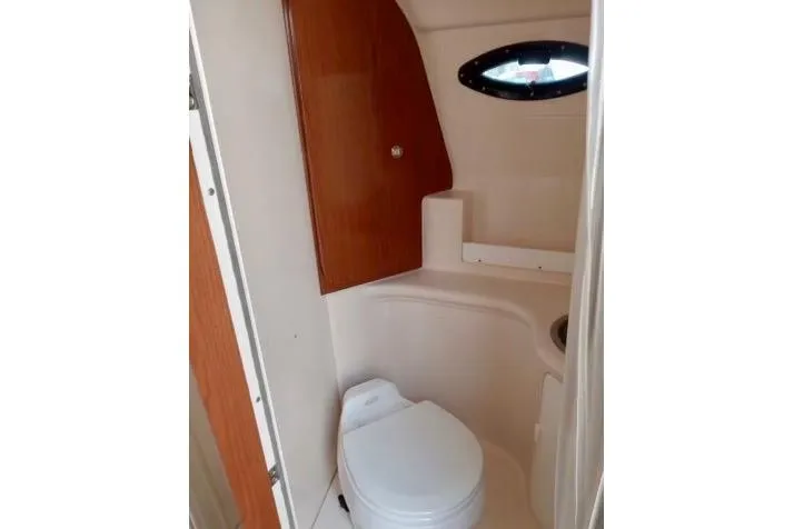 Slide: The Image of 2005 Regal Commodore 265 boat bathroom with toilet and wooden cabinet. - 7