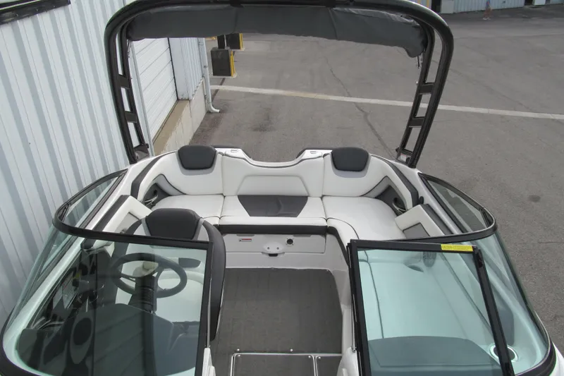 Slide: The Image of 2016 Yamaha Boats AR192 interior with seating and steering wheel, docked near a building. - 13