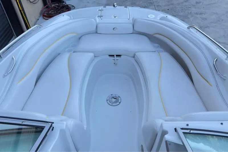 Slide: The Image of 2005 Crownline 220 EX boat interior with white seating and storage compartments. - 10