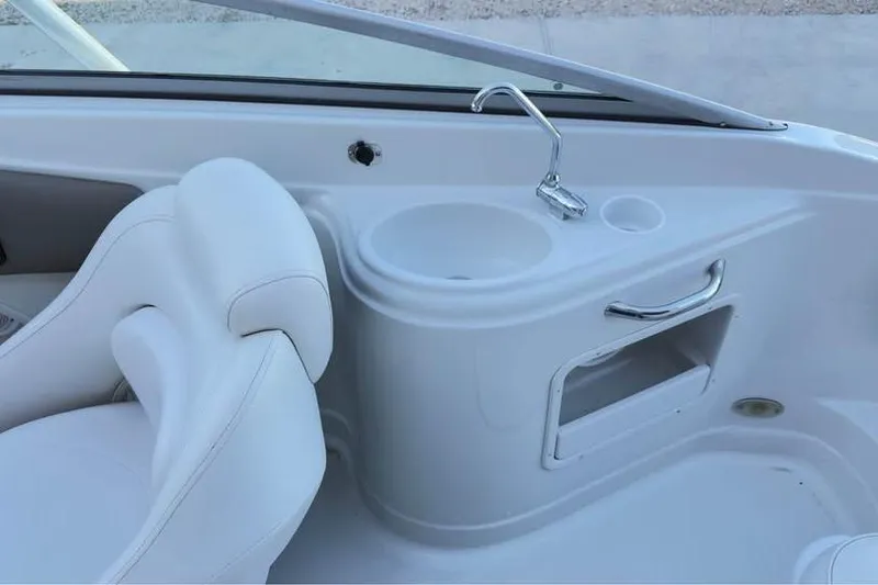 Slide: The Image of 2005 Crownline 220 EX boat interior with white seating and built-in sink. - 12