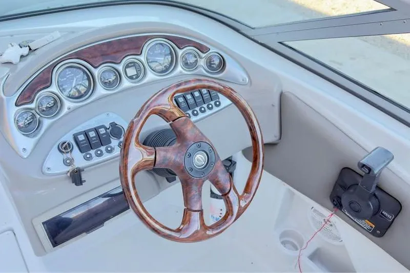 Slide: The Image of 2005 Crownline 220 EX boat dashboard with wood-grain steering wheel and instrument panel. - 6