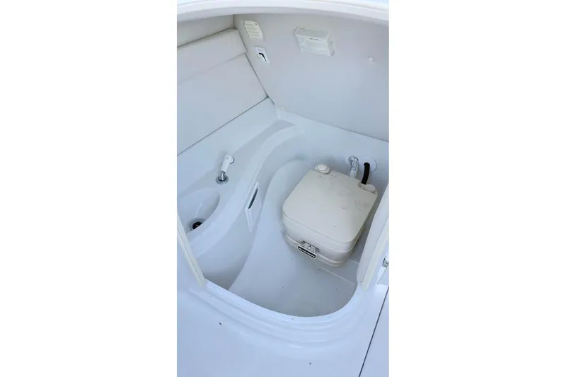 Slide: The Image of 2005 Crownline 220 EX boat interior with compact toilet and sink. - 8
