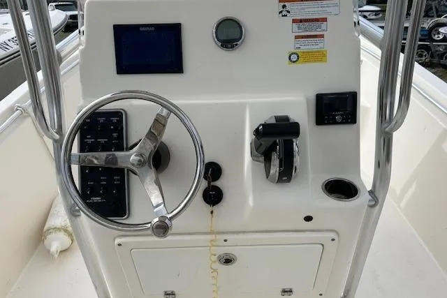 Slide: The Image of 2023 Cobia 220DC boat dashboard with steering wheel and control panel. - 3