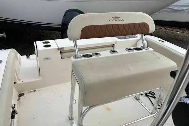 Slide: The Image of 2023 Cobia 220DC boat seating area with cup holders and cushioned backrest. - 5