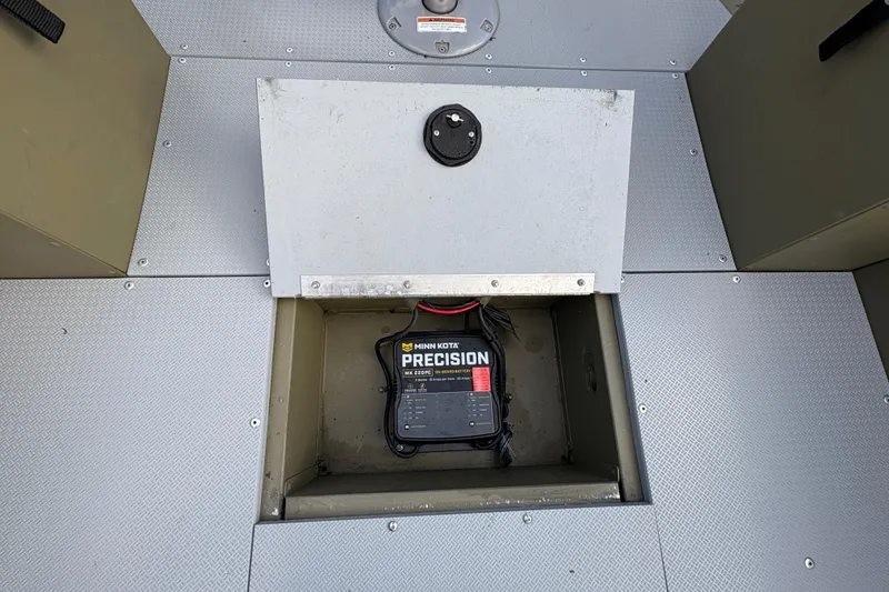 Slide: The Image of 2022 Lund 1800 Alaskan Tiller boat with Minn Kota Precision battery charger in storage compartment. - 13