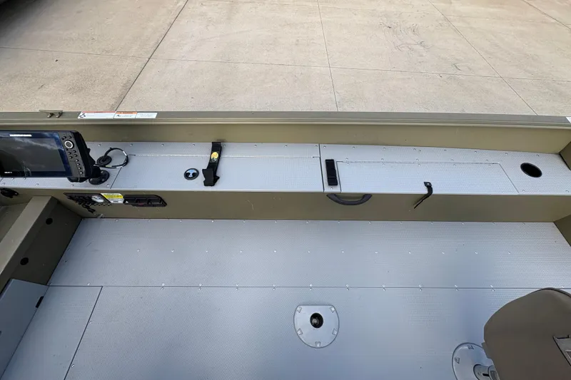 Slide: The Image of 2022 Lund 1800 Alaskan Tiller boat interior with control panel and storage compartments. - 15