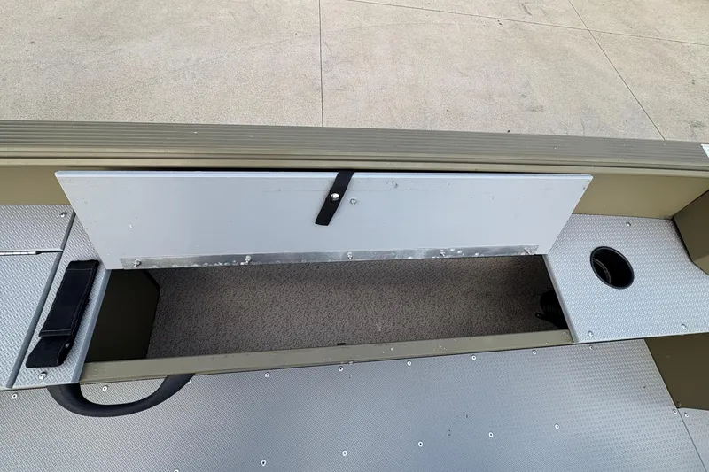 Slide: The Image of 2022 Lund 1800 Alaskan Tiller boat interior storage compartment and cup holder. - 16