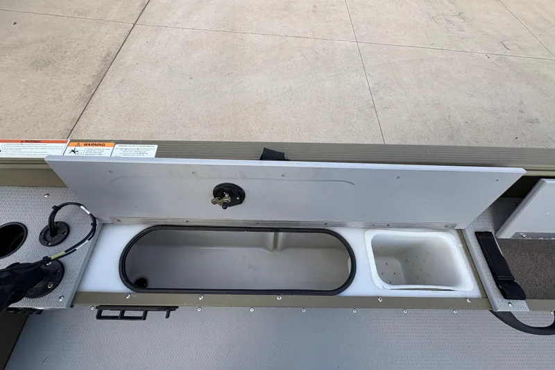 Slide: The Image of 2022 Lund 1800 Alaskan Tiller boat storage compartment with open lid. - 17