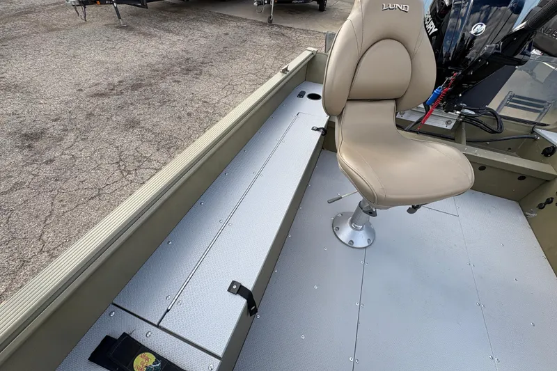 Slide: The Image of 2022 Lund 1800 Alaskan Tiller boat interior with beige seat and storage compartments. - 19