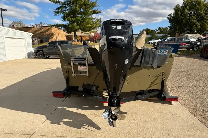 Slide: The Image of 2022 Lund 1800 Alaskan Tiller boat with Mercury 75 engine, parked outdoors. - 2