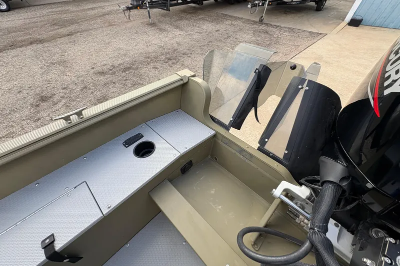 Slide: The Image of 2022 Lund 1800 Alaskan Tiller boat interior with motor and seating area. - 23