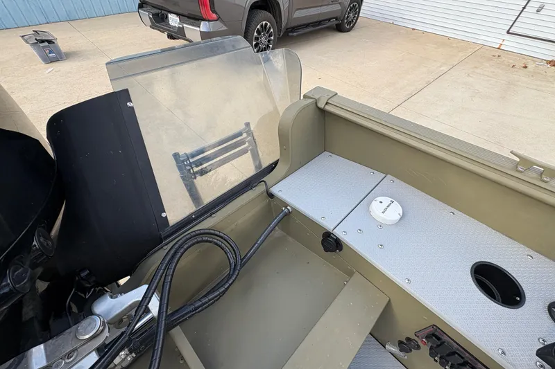 Slide: The Image of 2022 Lund 1800 Alaskan Tiller boat interior with control panel and seating area. - 24