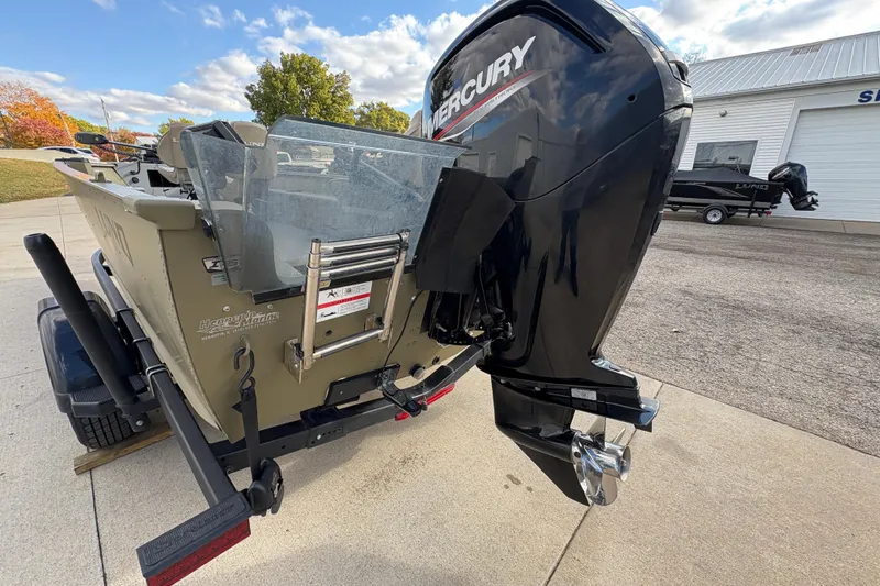 Slide: The Image of 2022 Lund 1800 Alaskan Tiller boat with Mercury outboard motor, parked outdoors. - 25