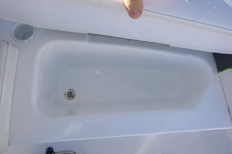 Slide: The Image of 2024 Tahoe T16 boat storage compartment with drain plug, open lid view. - 8