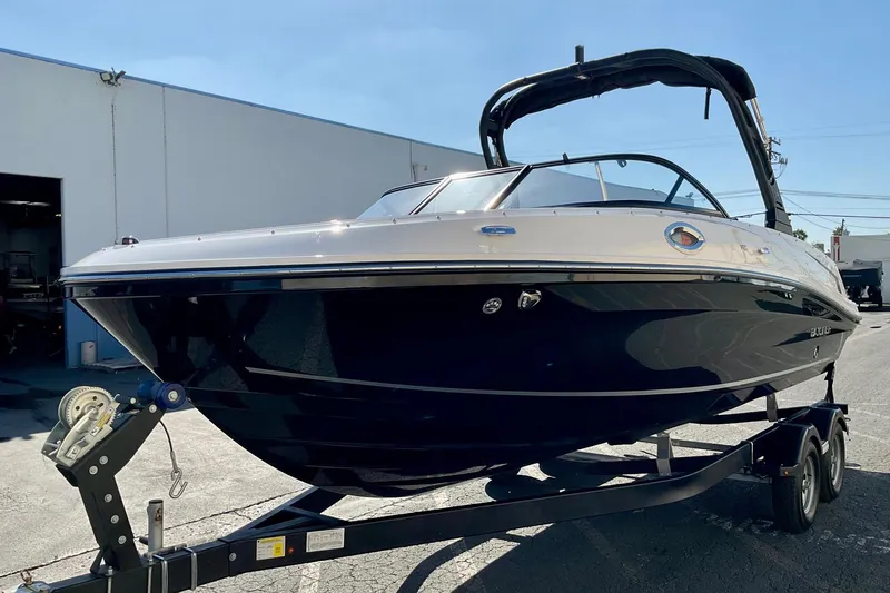 Slide: The Image of 2026 Bayliner VR6 Bowrider I/O on trailer, parked outdoors, sleek design. - 2