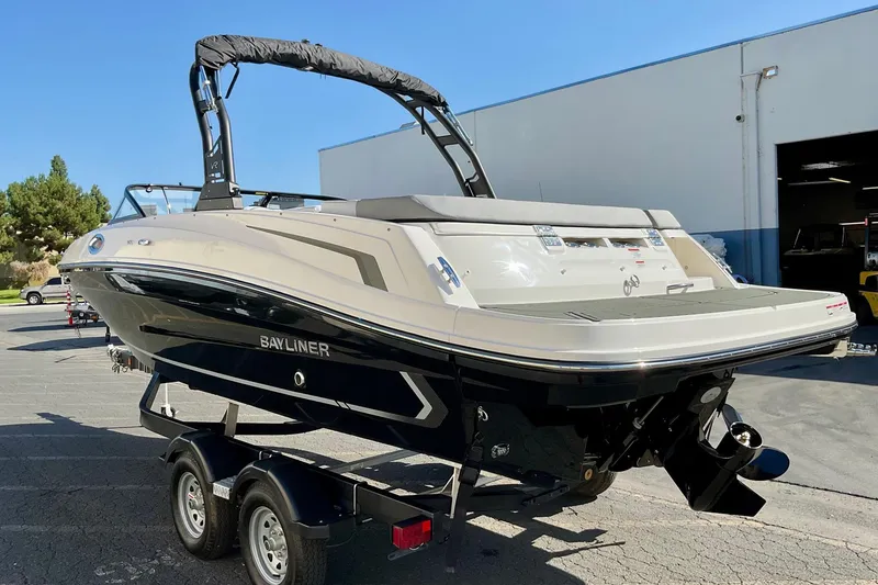 Slide: The Image of 2026 Bayliner VR6 Bowrider I/O on trailer, parked outdoors near a building. - 6