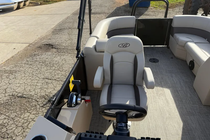 Slide: The Image of 2026 Bentley Pontoons Legacy 223 Navigator interior with beige seating and steering console. - 13