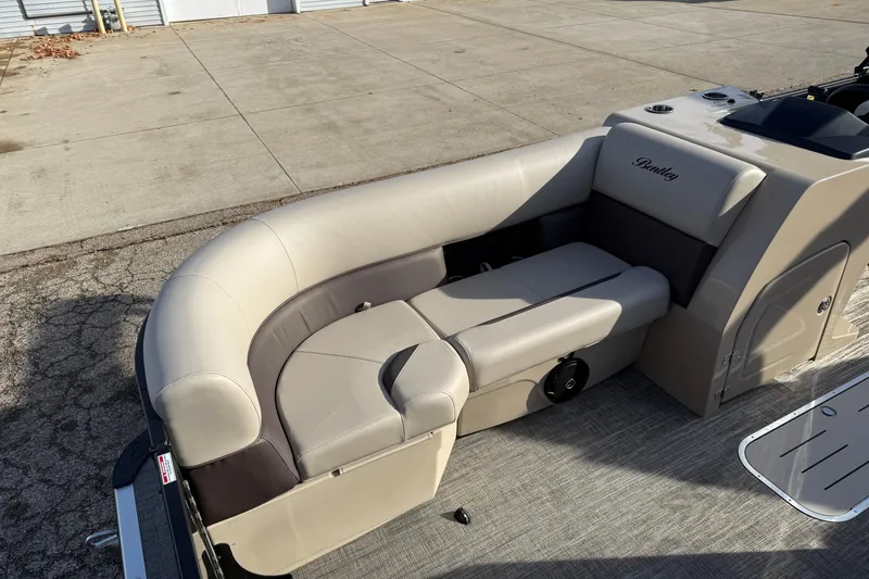 Slide: The Image of 2026 Bentley Pontoons Legacy 223 Navigator interior seating, beige upholstery, outdoor setting. - 9