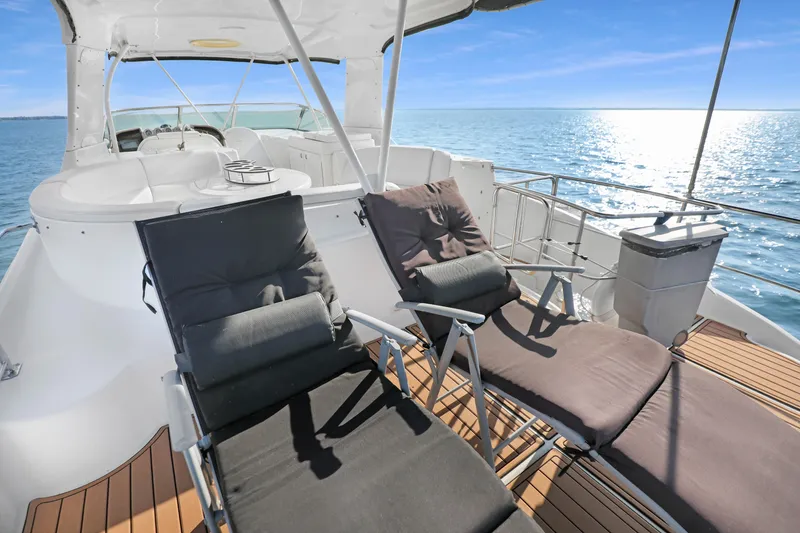 Slide: The Image of 2005 Carver 560 Voyager yacht deck with lounge chairs on a sunny day at sea. - 23