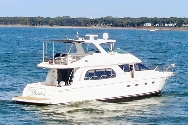 Slide: The Image of 2005 Carver 560 Voyager yacht cruising on a serene blue lake. - 5