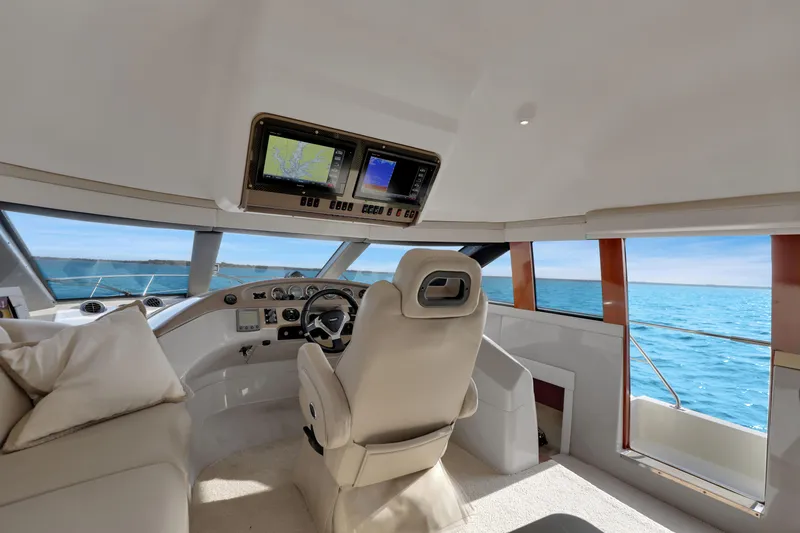 Slide: The Image of Luxurious 2005 Carver 560 Voyager yacht interior with helm, navigation screens, and ocean view. - 54