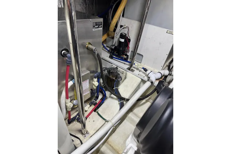 Slide: The Image of Engine room of a 2005 Carver 560 Voyager with visible plumbing and wiring. - 84