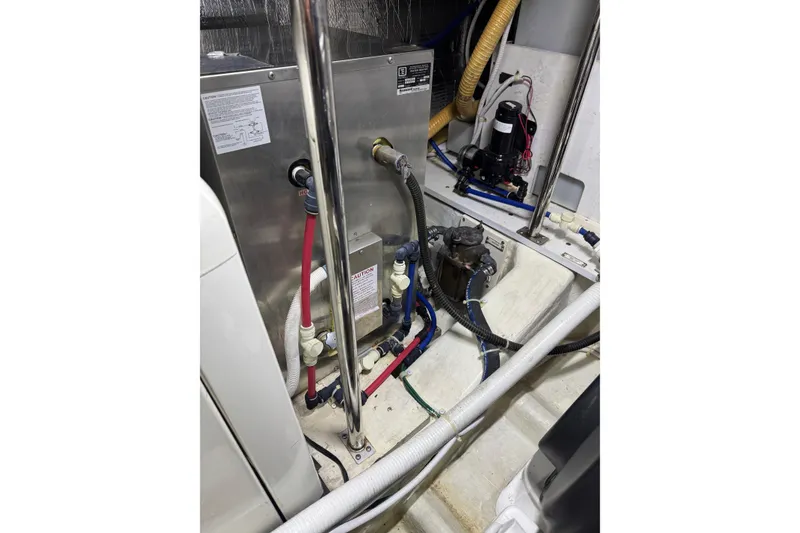 Slide: The Image of Engine room of a 2005 Carver 560 Voyager with visible plumbing and equipment. - 85