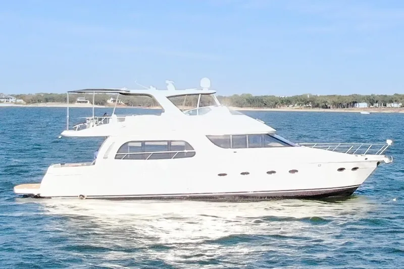 Slide: The Image of 2005 Carver 560 Voyager yacht cruising on open water under clear skies. - 12