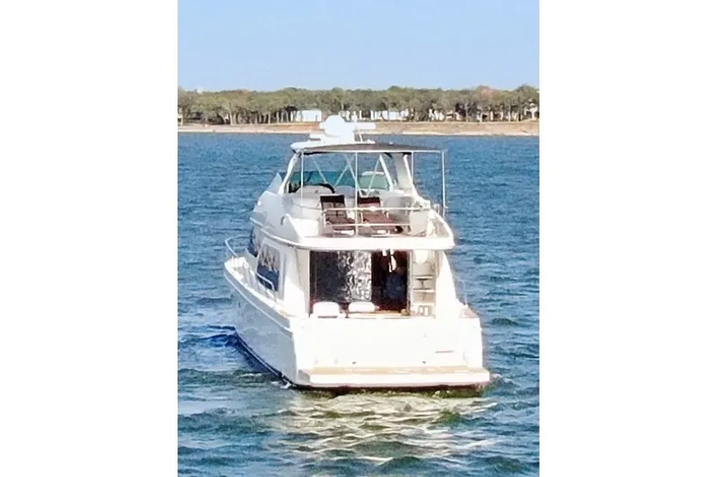 Slide: The Image of 2005 Carver 560 Voyager yacht cruising on a serene blue lake. - 15