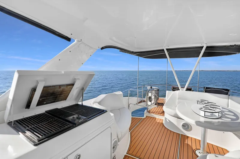 Slide: The Image of 2005 Carver 560 Voyager yacht deck with grill and seating, overlooking ocean. - 28